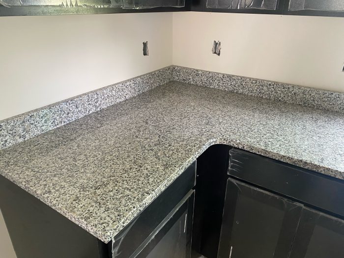 Granite countertops complementing sleek black kitchen cabinets.