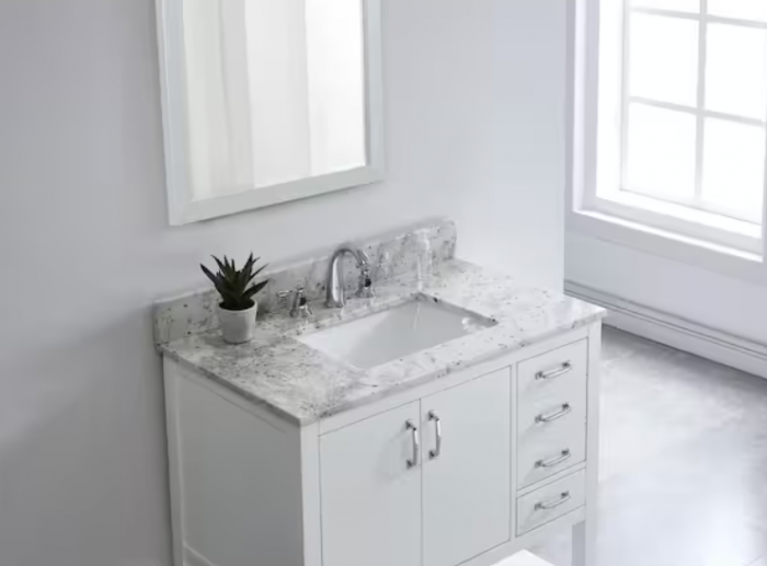 A white bathroom vanity with a sleek marble top.